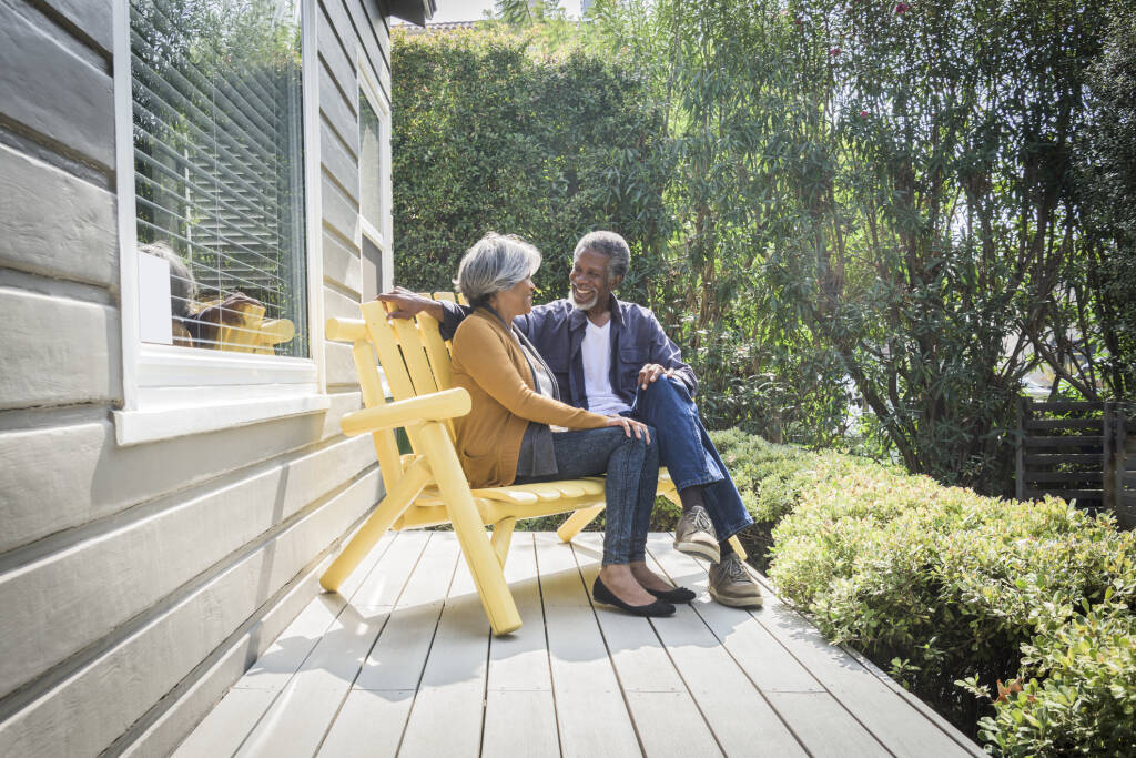 two people sitting outside on a bench chair
